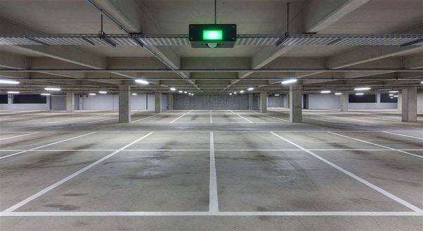 Parking space with ultrasonic occupancy sensor installed above showing vacant indicator light